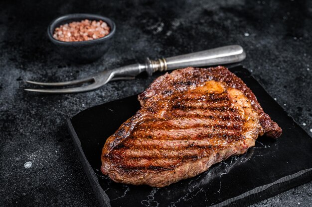 Gegrilltes Wagyu Rib Eye Steak marmoriertes Rindfleisch mit Salz Schwarzer Hintergrund Top-View