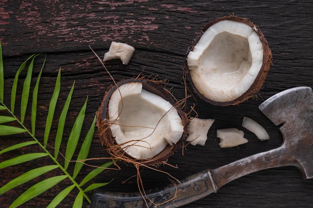 Gehackte Kokosnuss auf einem hölzernen Hintergrund, Draufsicht. Kokosmilch und Kokosflocken sind tropische Lebensmittel