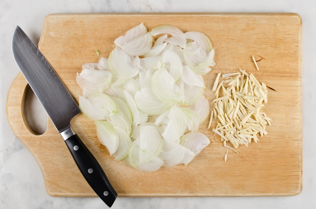 Gehackte Zwiebel und Knoblauch auf Holzschneidebrett