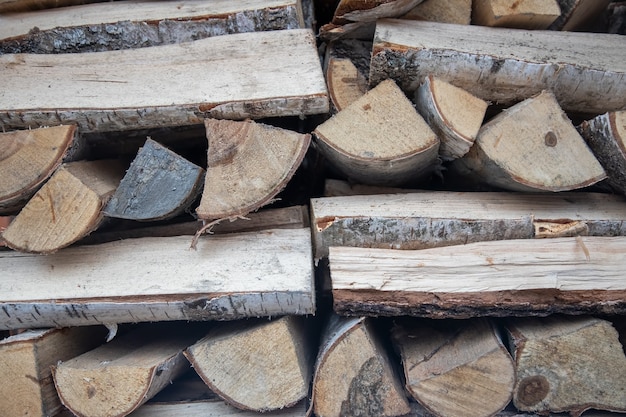 Gehacktes Brennholz für den Kamin sind ordentlich gefaltete Stapel, die Holz für die Heizsaison ernten