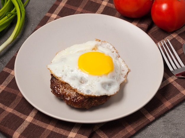 Gehacktes Steak mit Fleisch, garniert mit Tomaten und Frühlingszwiebeln