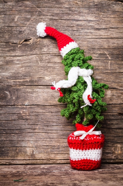 Gehäkelter Weihnachtsbaum mit Gerüst und Weihnachtsmütze, kalter Winterstil