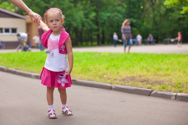 Gehen des kleinen Mädchens im Freien und Haben des Spaßes im Park