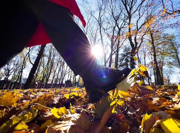 Gehen im Herbstpark, der trockene Blätter tritt