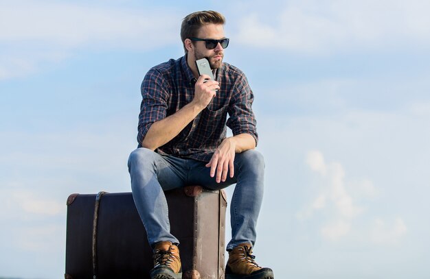 Gehen Sie einfach weg. Geschäftsmann mit Brille. Geschäftsreise. männlicher Modestil. sieht so trendy aus. sexy Mann Himmelshintergrund am Telefon sprechen. Macho-Mann-Touristen entspannen sich Tourtasche. Reisende warten auf Taxi. Bewegung.