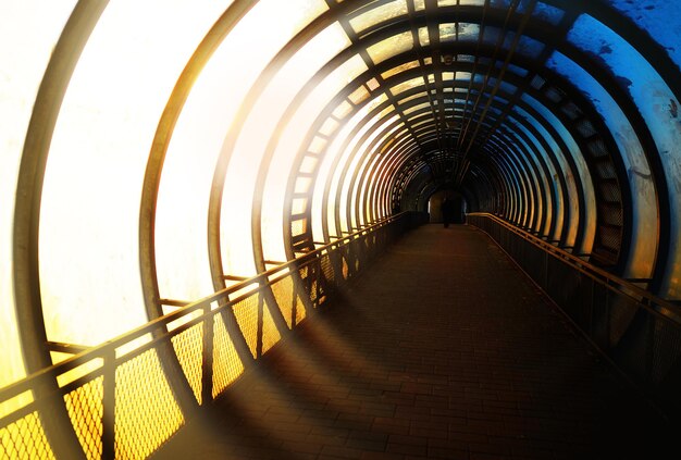 Gehender Mann im industriellen Tunnel im städtischen Hintergrund