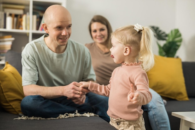 Gehörloses Kind mit Hörgerät, Cochlea-Implantat, hat Spaß mit Eltern, Hörgerät und Medizin, innovative Technologie und Diversitätskonzept