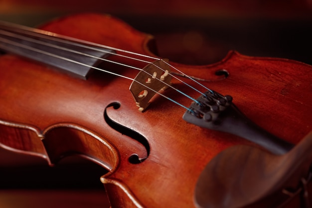 Geige im Retro-Stil und Bogen auf Holztisch, niemand. Klassisches Streichmusikinstrument, Musikkunst, alte Bratsche