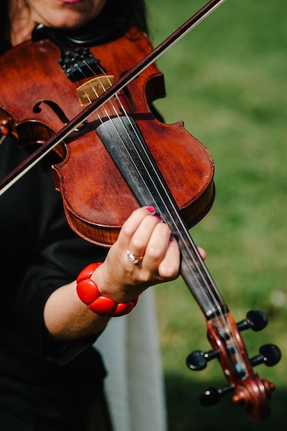 Geigenspielerhände Geiger spielt Geige auf dem Hintergrund des Feldes Leistung auf Natur Nahaufnahme von Musikinstrumenten Klassische Musik professioneller Cellospieler solo Nicht erkennbare Person