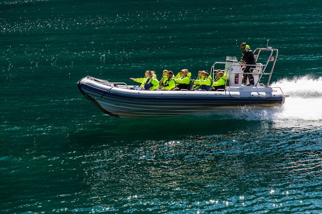 Geiranger, geirangerfjord, noruega - junho de 2019: barco de baga do navio turístico flutuante forro perto de geiranger em geirangerfjorden em dia de verão. marco famoso e destino popular.