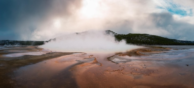 Gêiser de águas termais com água colorida na paisagem americana