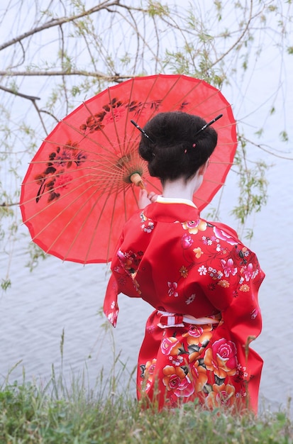 Foto geisha con sombrilla roja