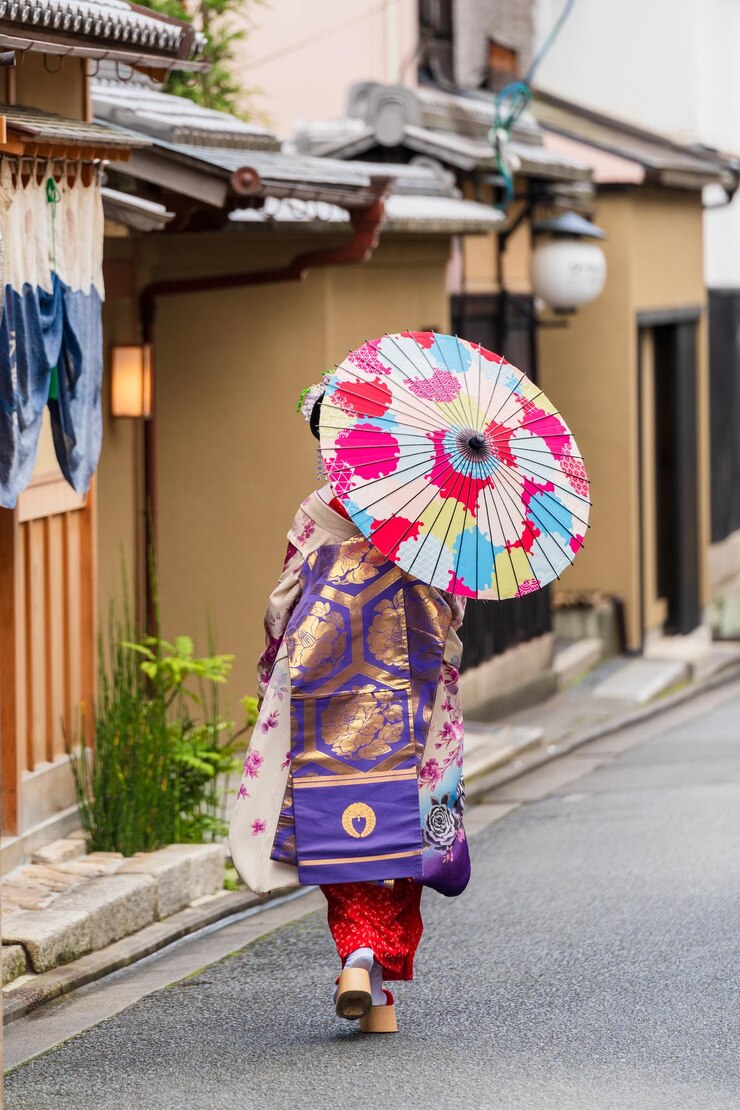 Geisha sosteniendo un paraguas de papel caminando por la calle en Gion Kyoto Japón