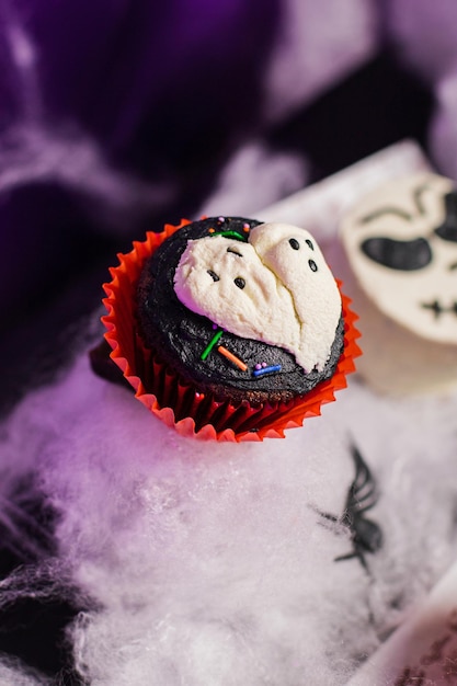 Foto geister-cupcake auf schokolade, geschmückt für halloween