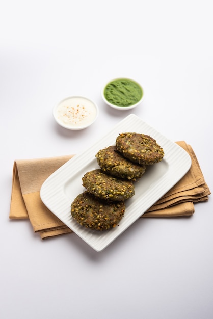 Gekeimtes Moong Dal Tikki oder Patties ist ein gesunder Snack aus Indien, serviert mit grünem Chutney und Quark