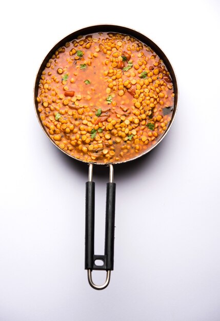 Gekochte Chana Dal Fry oder Split Bengal Gram Tadka serviert in einer Schüssel oder Pfanne, selektiver Fokus