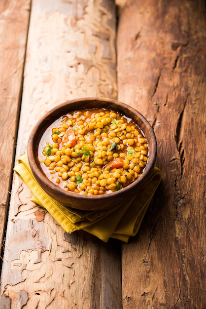 Gekochte Chana Dal Fry oder Split Bengal Gram Tadka serviert in einer Schüssel oder Pfanne, selektiver Fokus