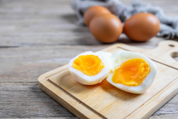 Gekochte Eier und rohe Eier auf einem Holztisch