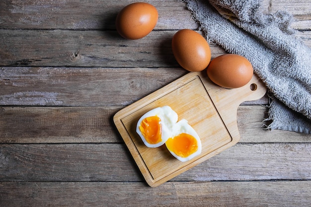Gekochte Eier und rohe Eier auf einem Holztisch