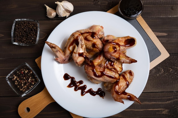 Gekochte Flügel in Teriyaki-Sauce auf einem weißen Teller Ein Gericht der asiatischen Küche