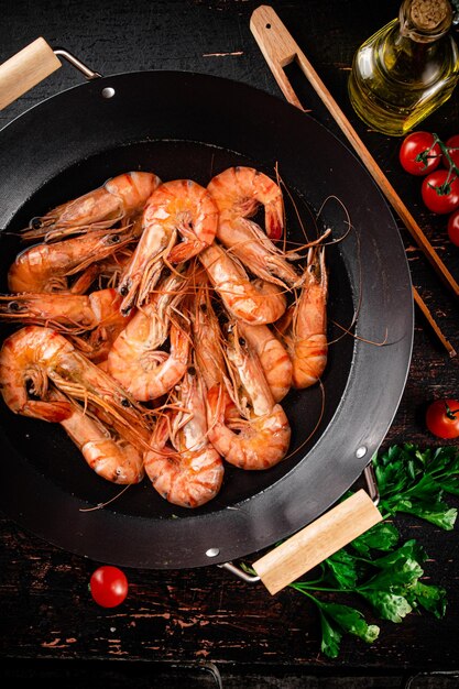 Gekochte Garnelen in einem Topf mit Petersilie und Tomaten