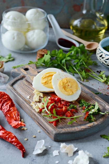 Gekochte Hühnereier. Der Prozess des Kochens gekochter marinierter Hühnereier mit Gemüse, Kräutern, Gewürzen und Tomatensauce.