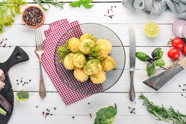 Gekochte Kartoffeln mit Dill in einer Schüssel Auf einem hölzernen Hintergrund Ansicht von oben Kopieren Sie Platz