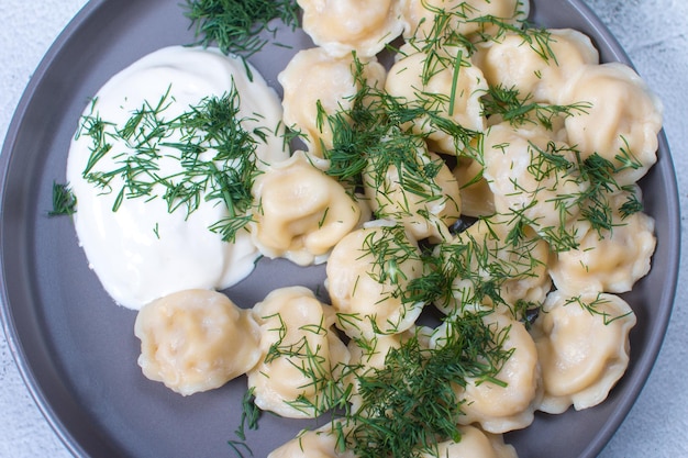 Gekochte Knödel mit Dill und Sauerrahm Hausgemachte Knödel mit Fleisch