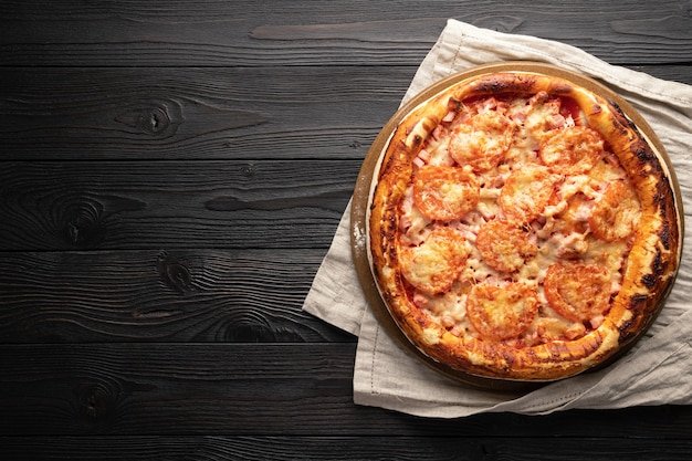 Gekochte Pizza auf Holzhintergrund, Platz für Text, Ansicht von oben