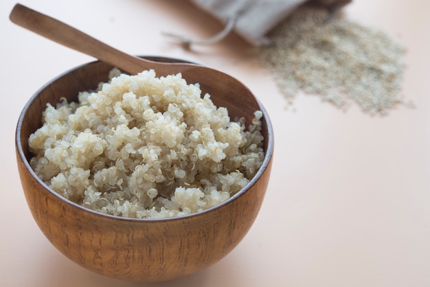 gekochte Quinoa in Schüssel und Holzlöffel