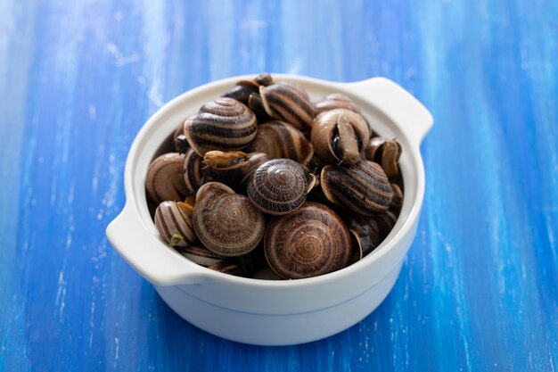 Gekochte Schnecken mit Kräutern in weißer Schale