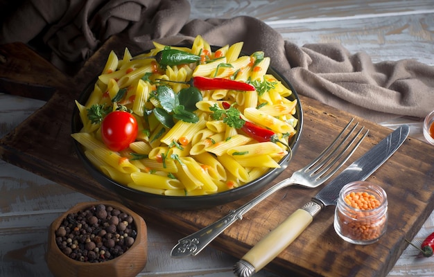 Foto gekochte spaghetti mit gewürzen und gemüse auf einem alten hintergrund