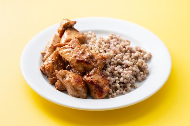 Gekochter Buchweizen mit Huhn in Soße auf weißem Teller