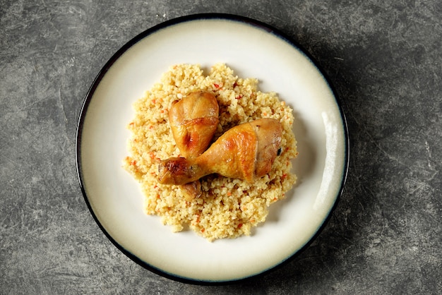 Gekochter Bulgur mit Gemüse und gebackenen Hähnchenkeulen