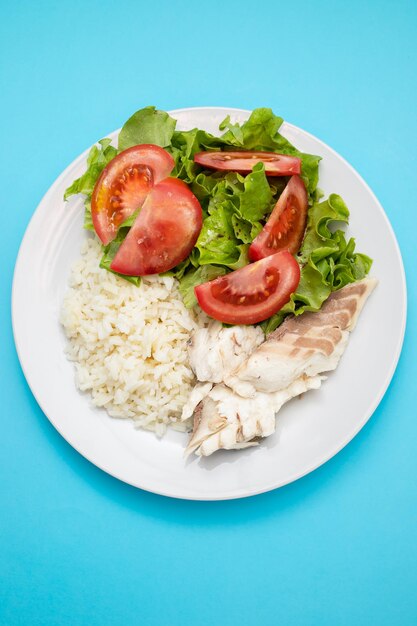 Gekochter frischer Fisch mit gekochtem Reis und frischem Salat auf dem Teller