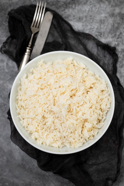 Gekochter Reis in einer Schüssel auf grauem Hintergrund