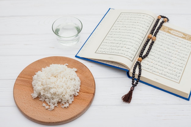 Foto gekochter reis mit quran und perlen auf dem tisch