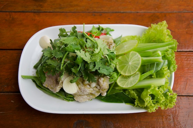 Gekochtes Schweinefleisch mit Limetten-Knoblauch und Chili und Zitrone, würzige süße Thai-Sauce namens Moo Ma Nao, serviert mit viel Gemüse