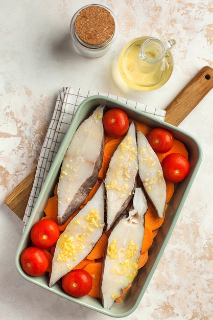 Gekühlte Heilbuttsteaks in einer Auflaufform mit Tomaten und Süßkartoffeln