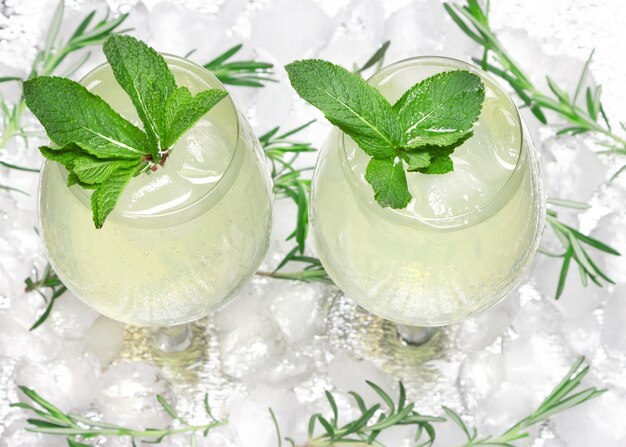 Gekühltes Getränk mit Minzblättern in Glascocktailbechern auf Eiswürfeln. Kalter Mojito