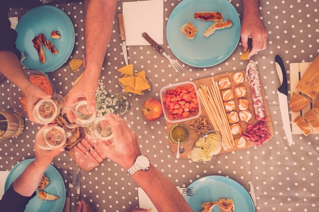 Foto gekürzte hände, die champagnerflöten am tisch toasten