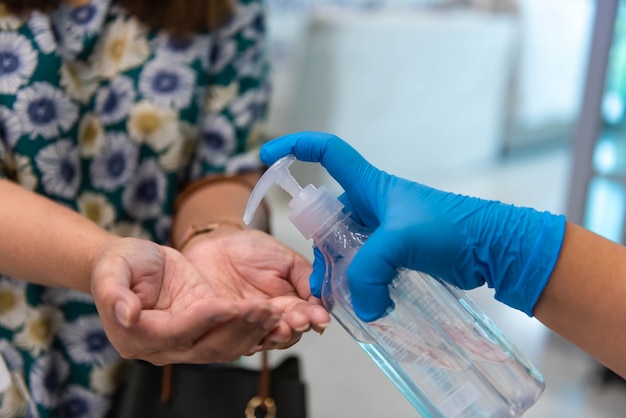 Foto gel desinfectante de prensa manual en la mano del cliente para prevenir el coronavirus