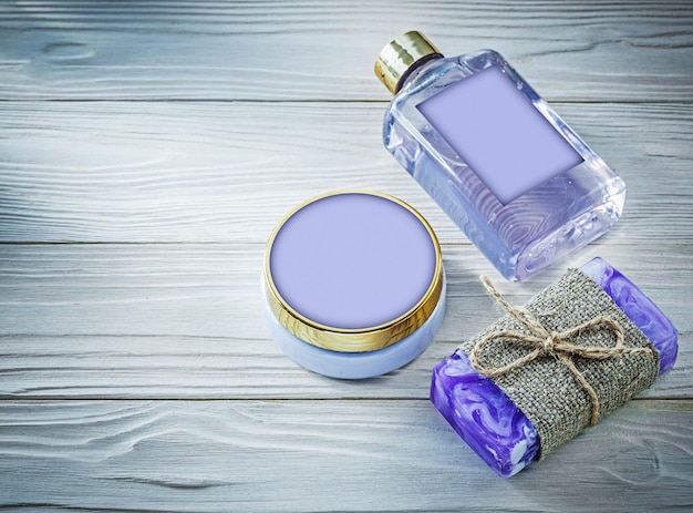 Gel de ducha de jabón hecho a mano de lavanda y loción corporal en concepto de baño de tablero de madera