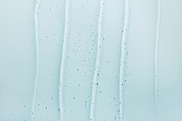 Gel líquido cosmético abstracto fondo azul Frotis de producto hidratante transparente