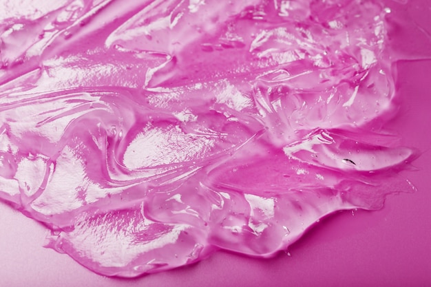 Gel líquido transparente em uma superfície rosa