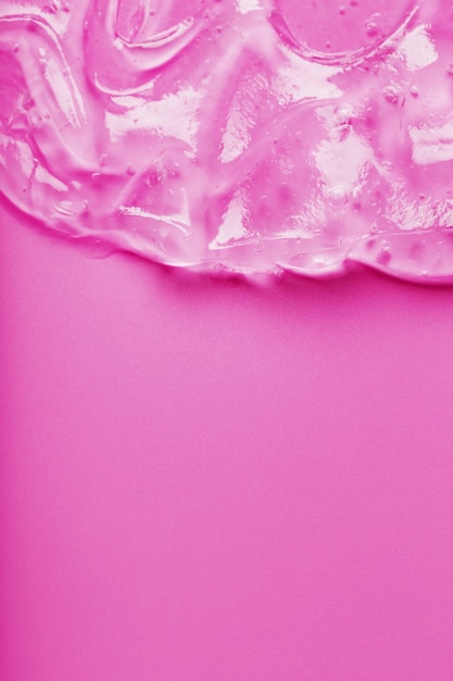 Gel líquido transparente sobre una superficie rosa