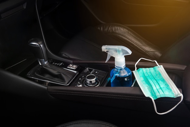 Gel de manos y mascarilla de alcohol etílico para adultos colocados en el asiento del automóvil en el concepto de automóvil para covid-19