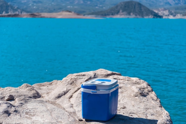 Geladeira portátil no meio da montanha com lago celestial nas férias de volta