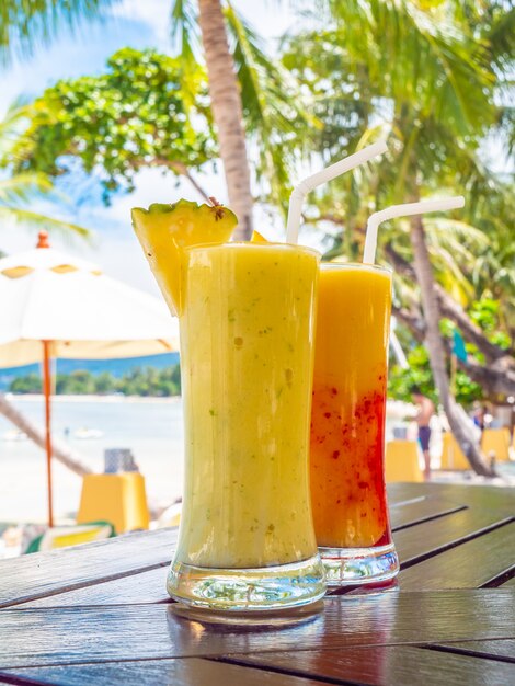 Gelado bebendo smoothies de vidro na mesa de madeira