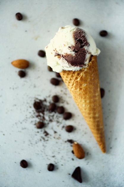 Gelado do chocolate, da baunilha e do café no cone do waffle com os feijões de café na pedra cinzenta. conceito de comida de verão, copie o espaço. gelado saudável sem glúten